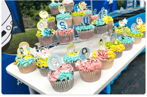 Cupcakes decorados con íconos y colores corporativos en activación de Surexs vinculada a beneficios y seguros para colaboradores.